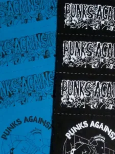Slide 6: Two layers of patch sheets with bits of the long PUNKS AGAINST APARTHEID and circular PUNKS AGAINST APARTHEID logos visible. Half the patches are black with white ink, the others blue with black ink.